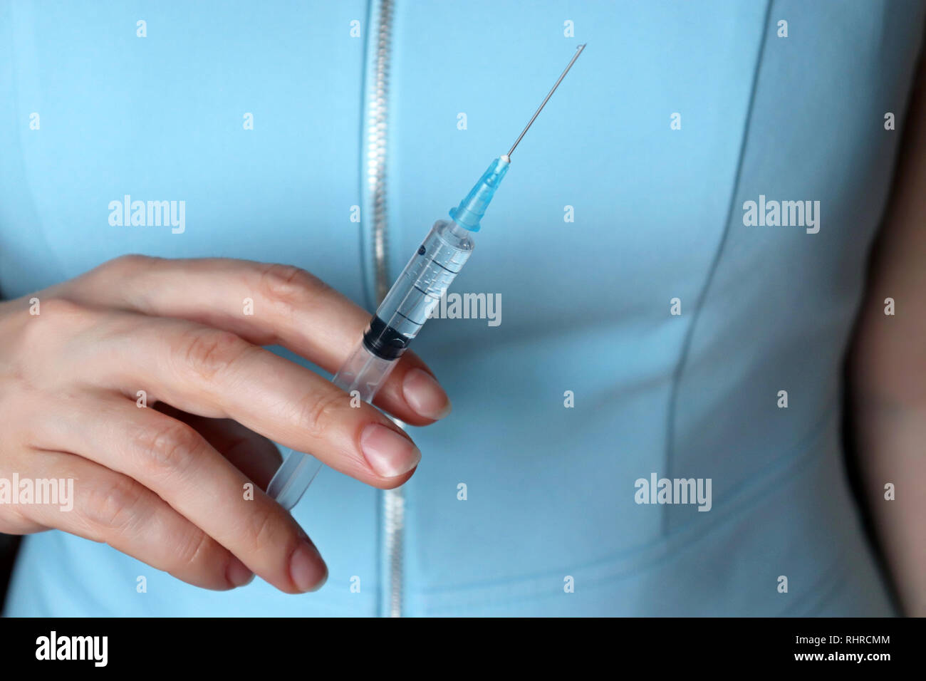 Medico con una siringa, donna in blue coat preparazione per iniezione. Concetto di vaccinazione, il trattamento in clinica di chirurgia plastica Foto Stock