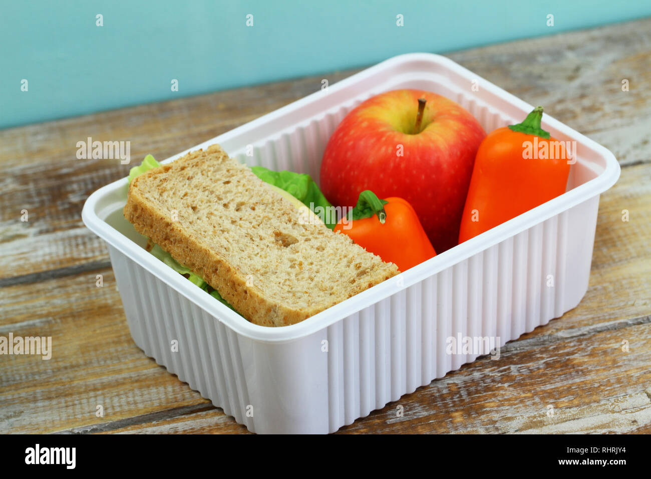 Scuola di sano lunchbox contenente formaggio marrone sandwich, croccante di peperone giallo e rosso apple Foto Stock