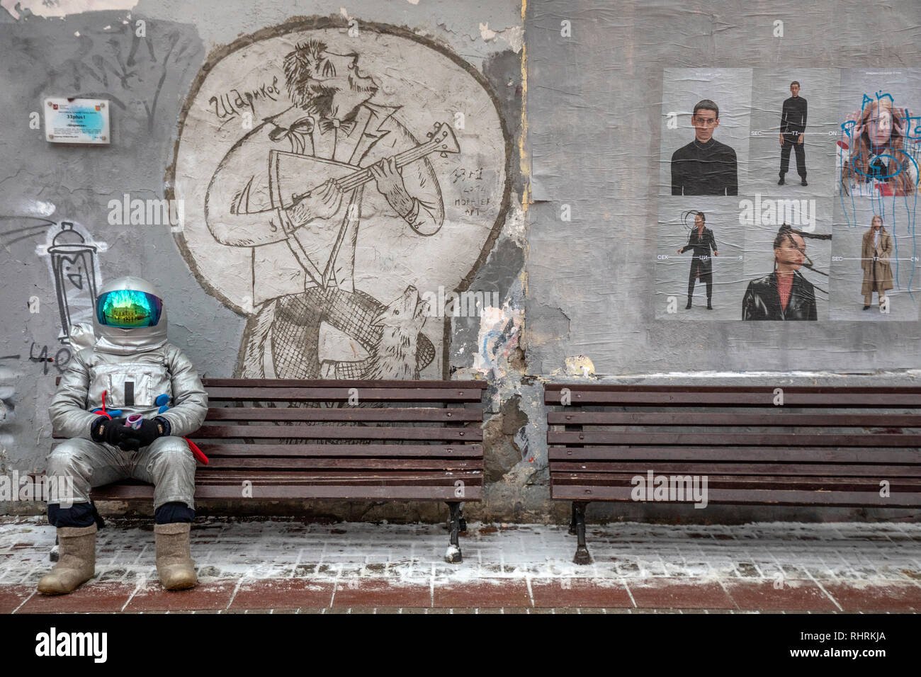 Un uomo vestito da astronauta seduto su una panchina in via Arbat nel centro di Mosca, Russia Foto Stock