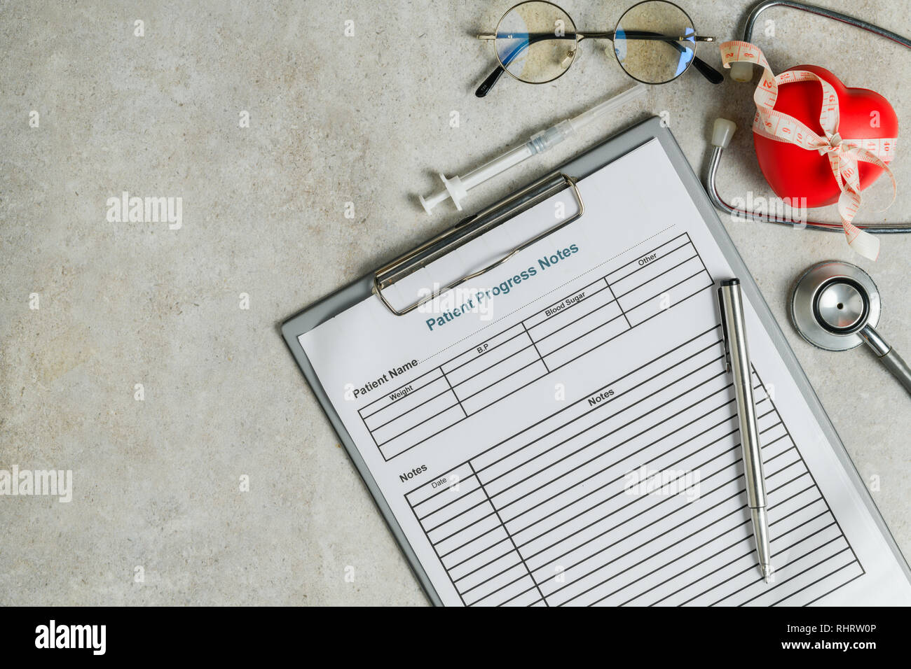 Il decorso del paziente nota con lo stetoscopio e il cuore rosso su tavola, Health care concept Foto Stock