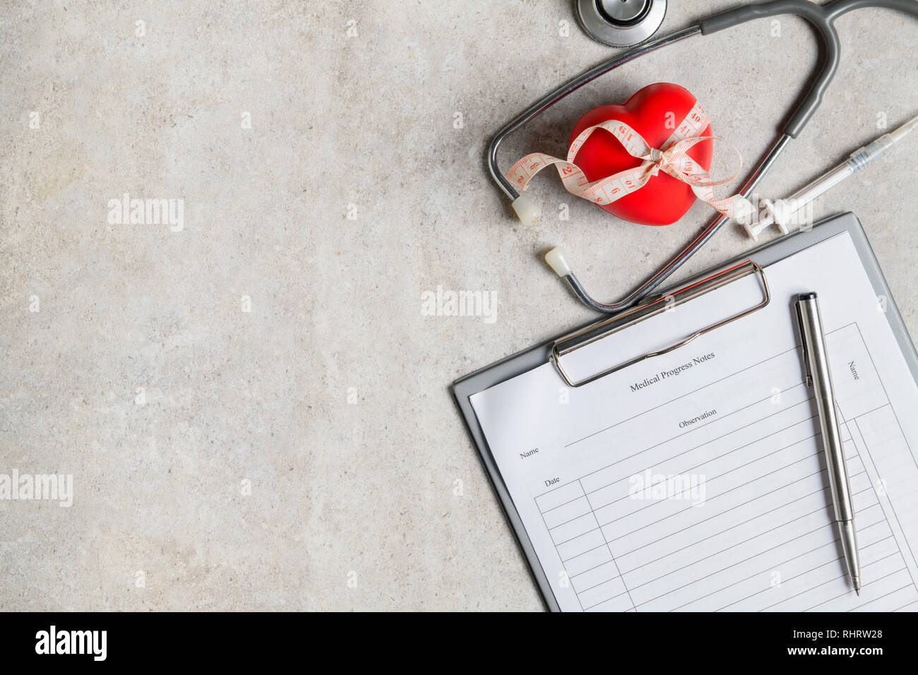 Il decorso del paziente nota con lo stetoscopio e il cuore rosso su tavola, Health care concept Foto Stock