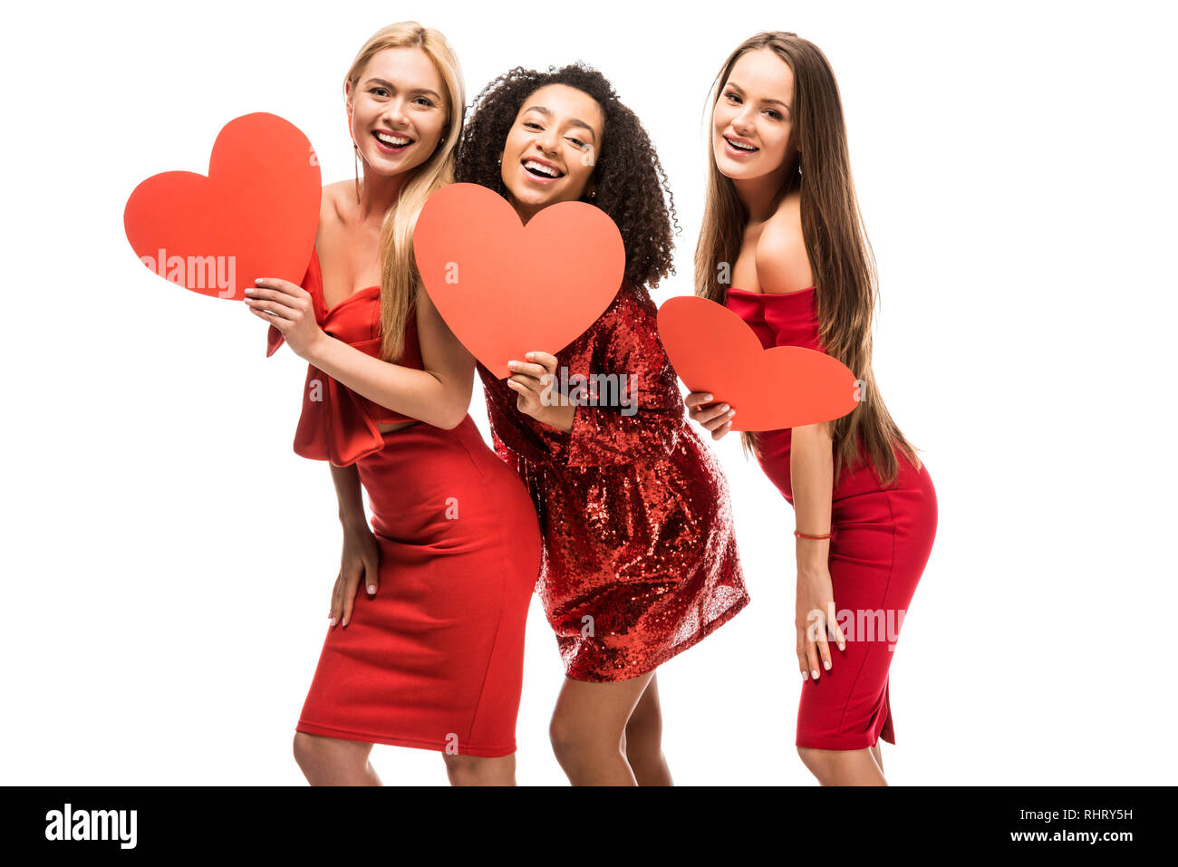 Bella felice ragazze multietnica holding cuori di cartone e in posa isolato su bianco Foto Stock