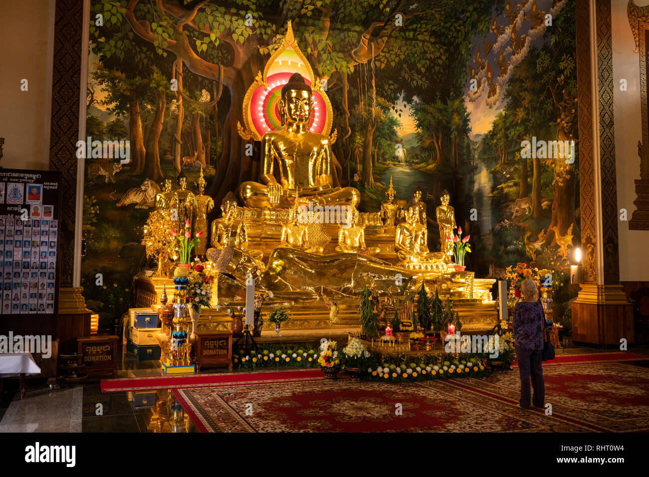 Cambogia, Phnom Penh, Wat Botum, all'interno del tempio di fiori di loto, visitatore ammirando seduta dorato e il Buddha reclinato figure Foto Stock