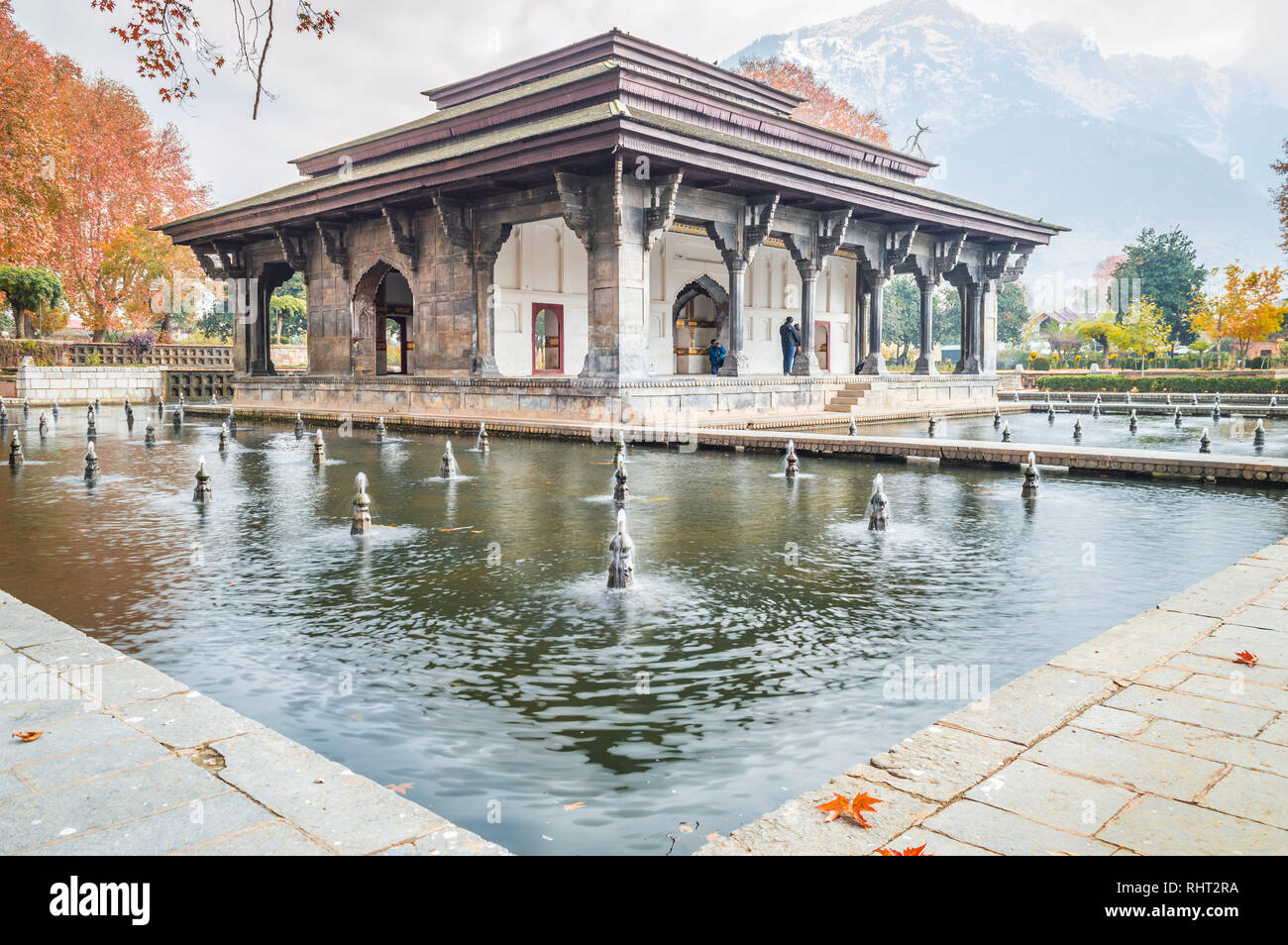 Vista obliqua di Mughal edificio del patrimonio con la riflessione in piscina durante la stagione autunnale in Shalimar Bagh Giardino Mughal del Kashmir Foto Stock