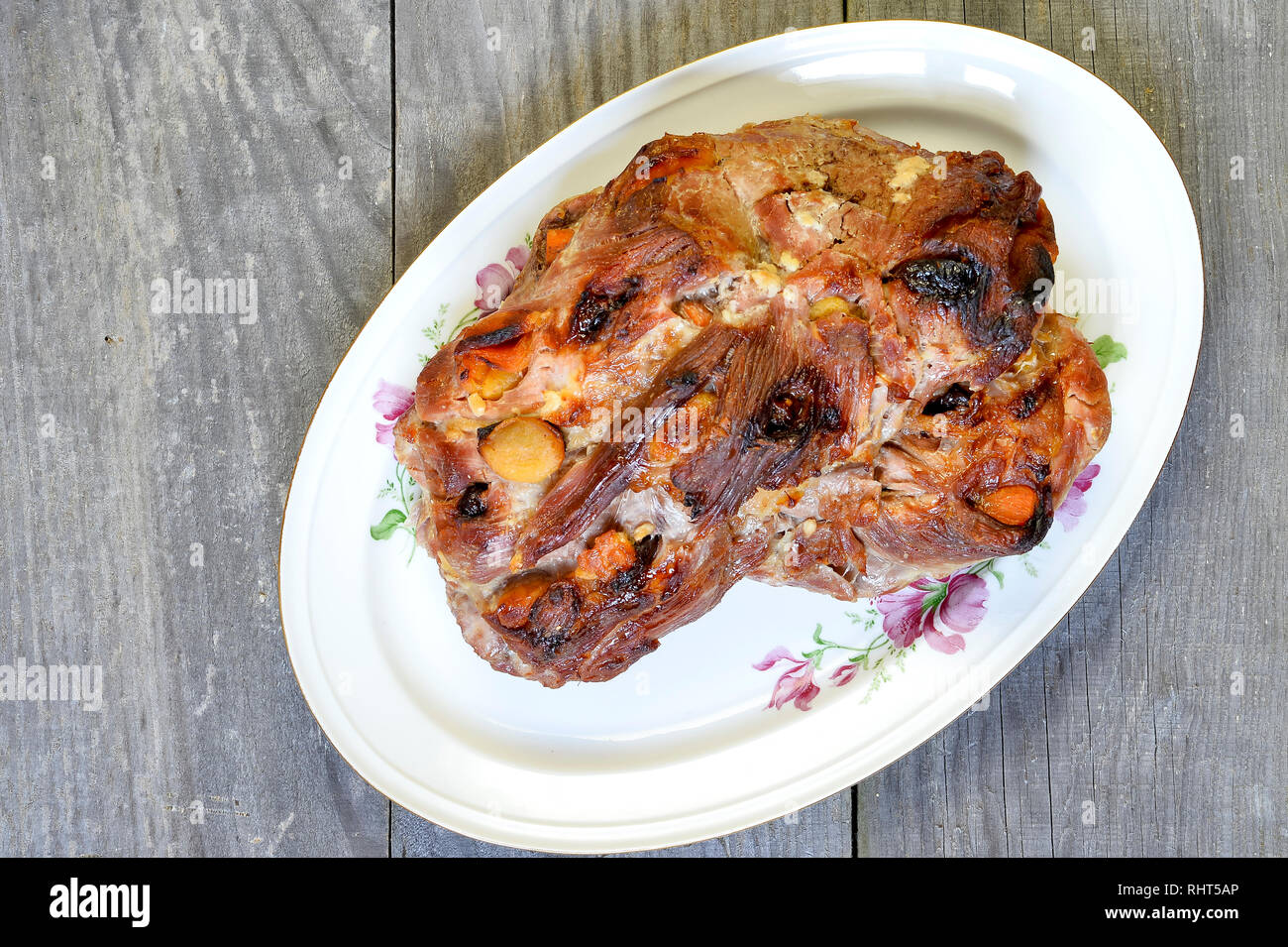 La carne di maiale cotta al forno in un grande pezzo di pre-ripiene di frutta secca con albicocche secche e le prugne secche. Foto Stock