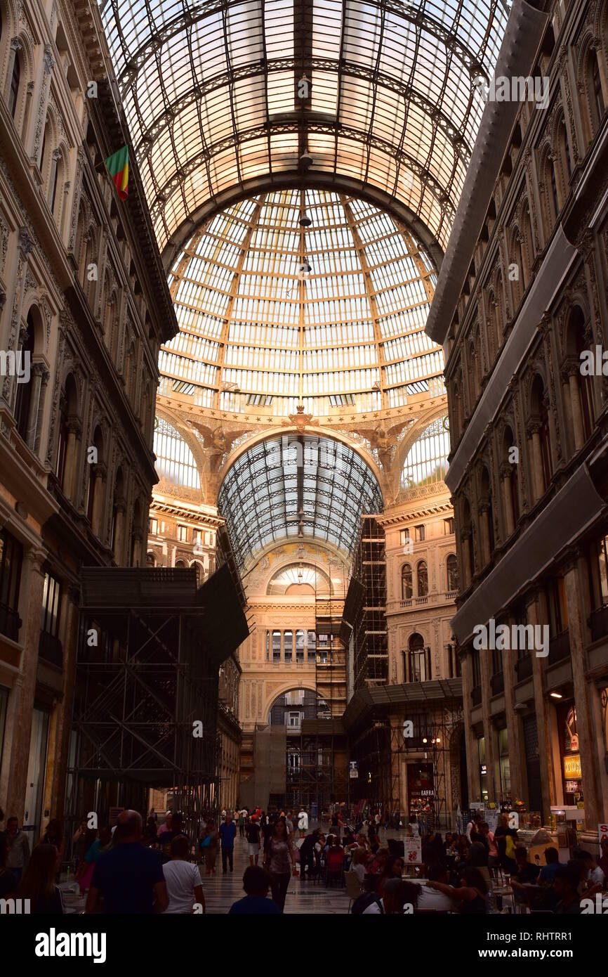 La folla di gente che passeggia attraverso pubblico galleria per lo shopping della Galleria Umberto a Napoli durante la stagione estiva. Foto Stock