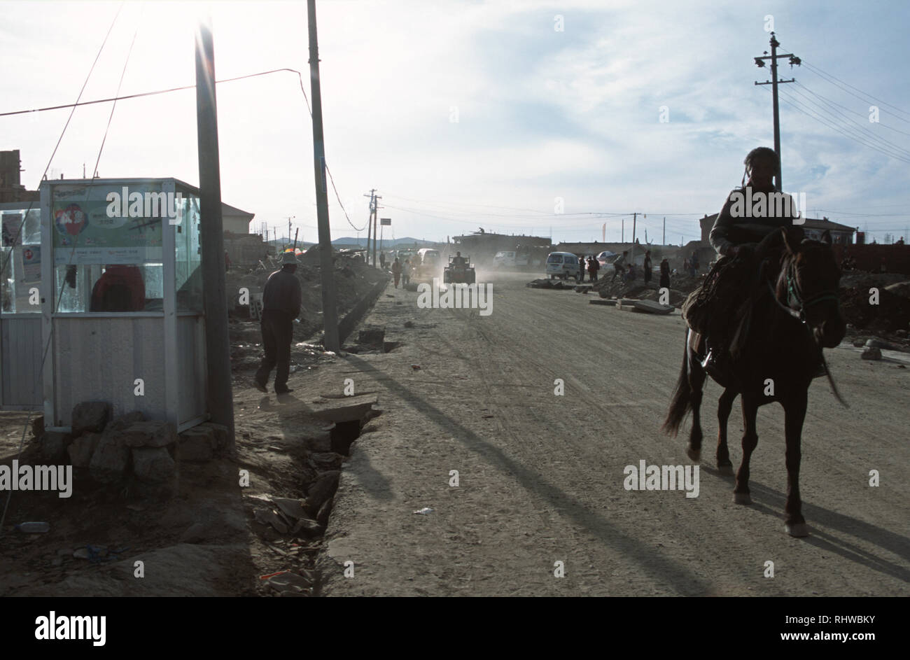 Cavallo e cavaliere passeggiate Tangkor passato solo telefono. Situato su vaste praterie di Aba, Tangkor è vero nomade della terra; la città, una volta abbandonati Foto Stock