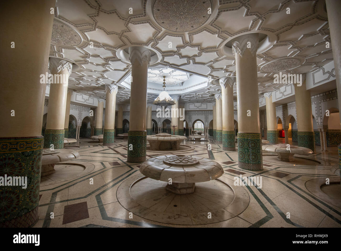 All'interno della moschea di Hassan II con corridoio interno con colonne. Archi arabi, ornamenti, lampadario e illuminazione. Casablanca, Marocco la più grande moschea Foto Stock