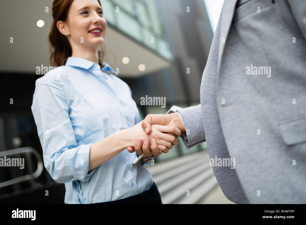 Business e concetto di ufficio. Imprenditore e imprenditrice stringono le mani Foto Stock