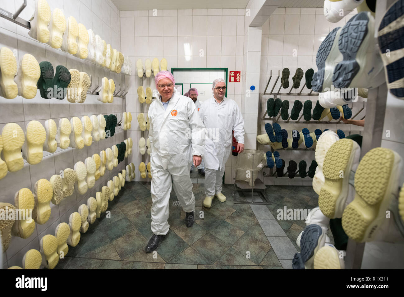 Garrel, Germania. 04 feb 2019. Stephan Weil (SPD, l), il Ministro Presidente della Bassa Sassonia, è nel macello Böseler-Goldschmaus durante il tour in una stanza dove le scarpe igienico per pulire la zona sono in funzionamento. Credito: Mohssen Assanimoghaddam/dpa/Alamy Live News Foto Stock
