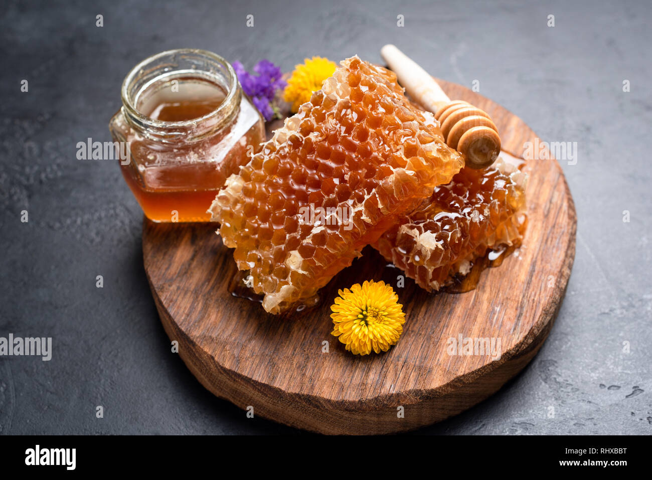 I nidi d'ape, di fiori e di un vasetto di miele. Fresca naturale miele grezzo Foto Stock