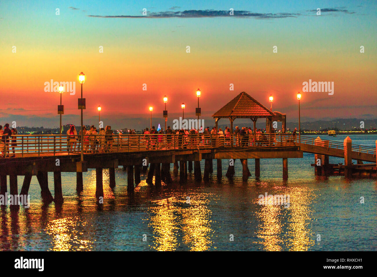 Scenic vista al tramonto del Coronado Attracco su Coronado Island, California, Stati Uniti d'America. Cittadini e turisti a piedi sul vecchio molo in legno riflettendo in San Foto Stock