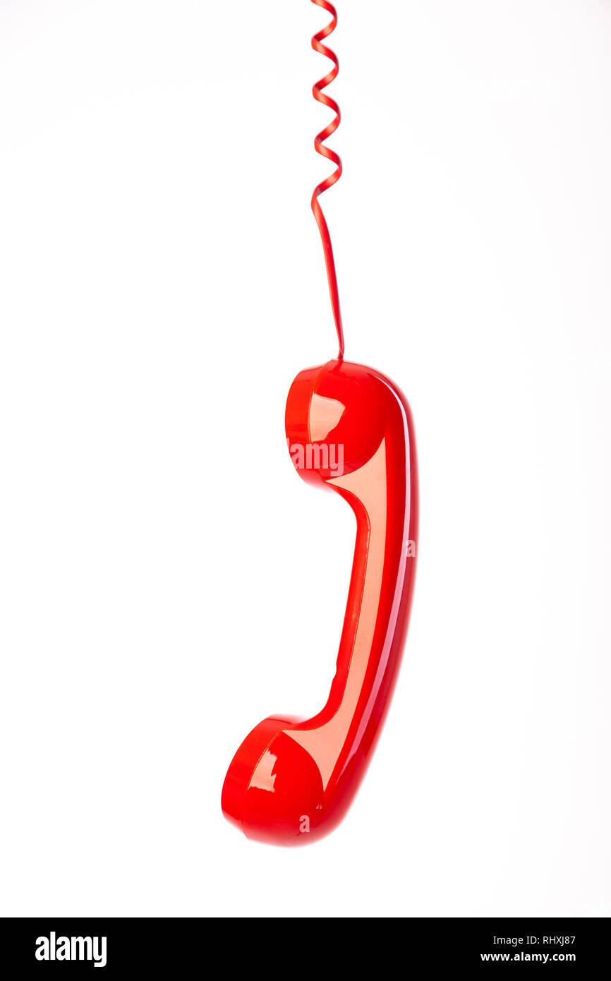 Un ricevitore telefonico rosso appeso è cavo. Foto Stock