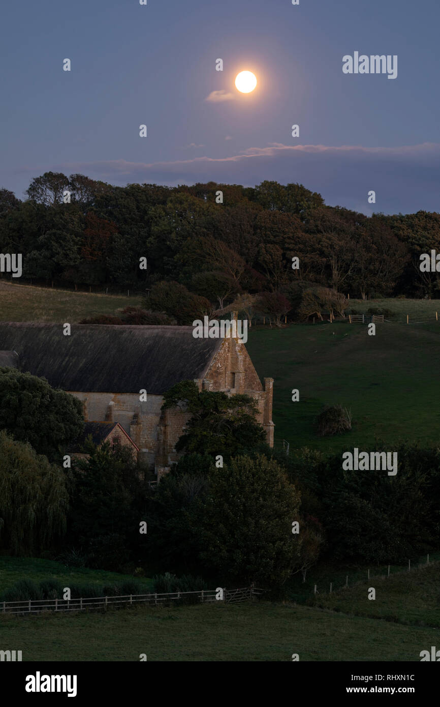 Un vecchio granaio inglese sotto la luna piena Foto Stock