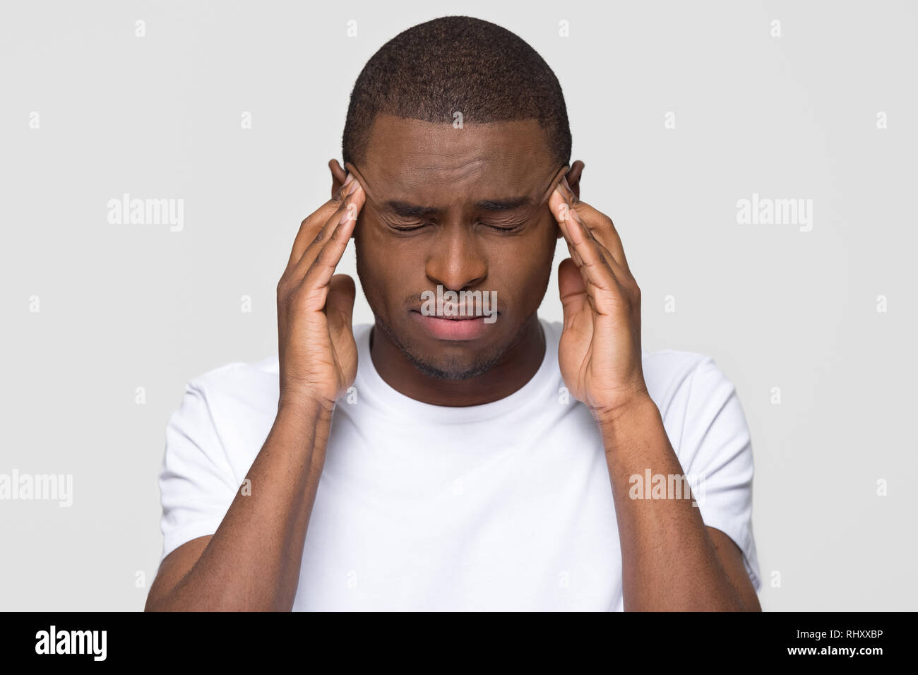 Sottolineato giovane americano africano uomo sensazione di dolore terribile mal di testa Foto Stock