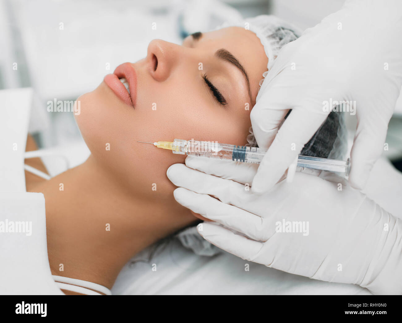 La donna la ricezione di tossina botulinica iniezione sul viso Foto Stock