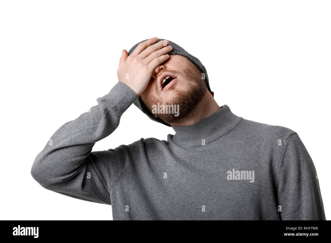 Oh mio Dio! Ritratto di triste uomo barbuto in grey hat su sfondo bianco Foto Stock