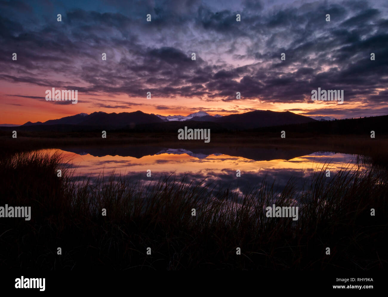 Un perfetto riflesso di bianco Princess Peakat sunrise in Fielding lago vicino Paxson, Alaska Foto Stock