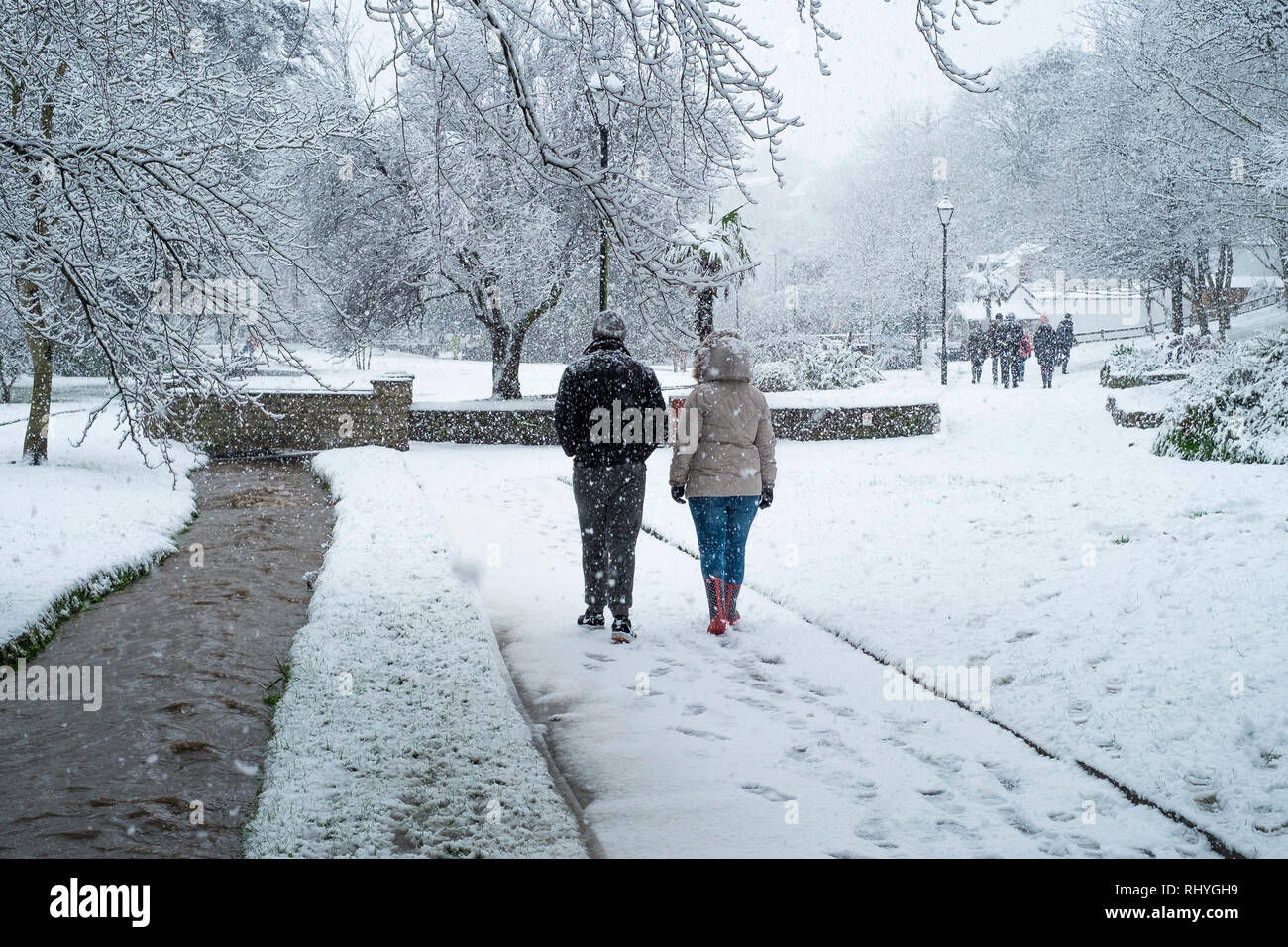La gente camminare attraverso la nevicata nel Parco Trenance a Newquay in Cornovaglia. Foto Stock