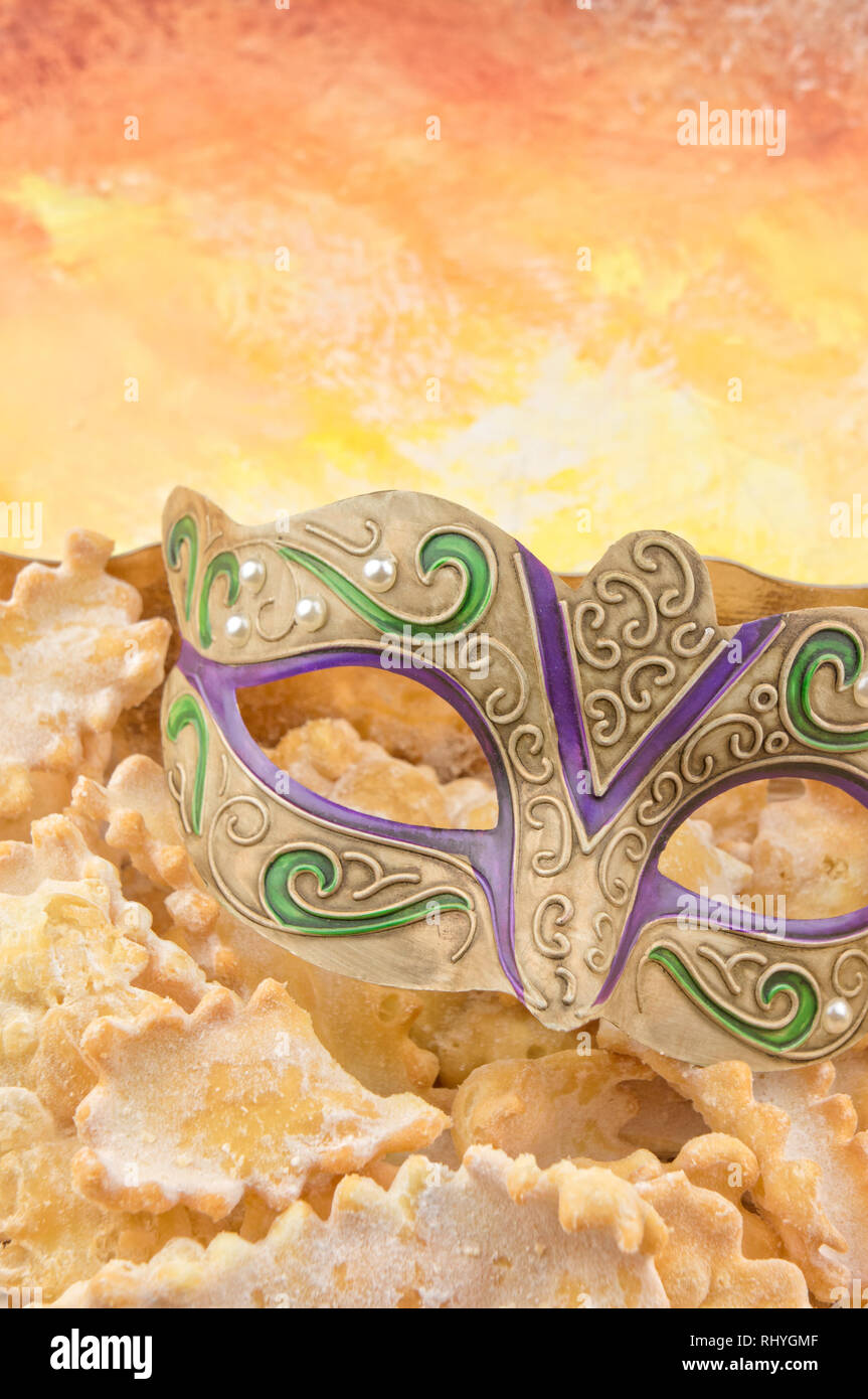 Decorate maschera di Carnevale e dolci fritti Foto Stock