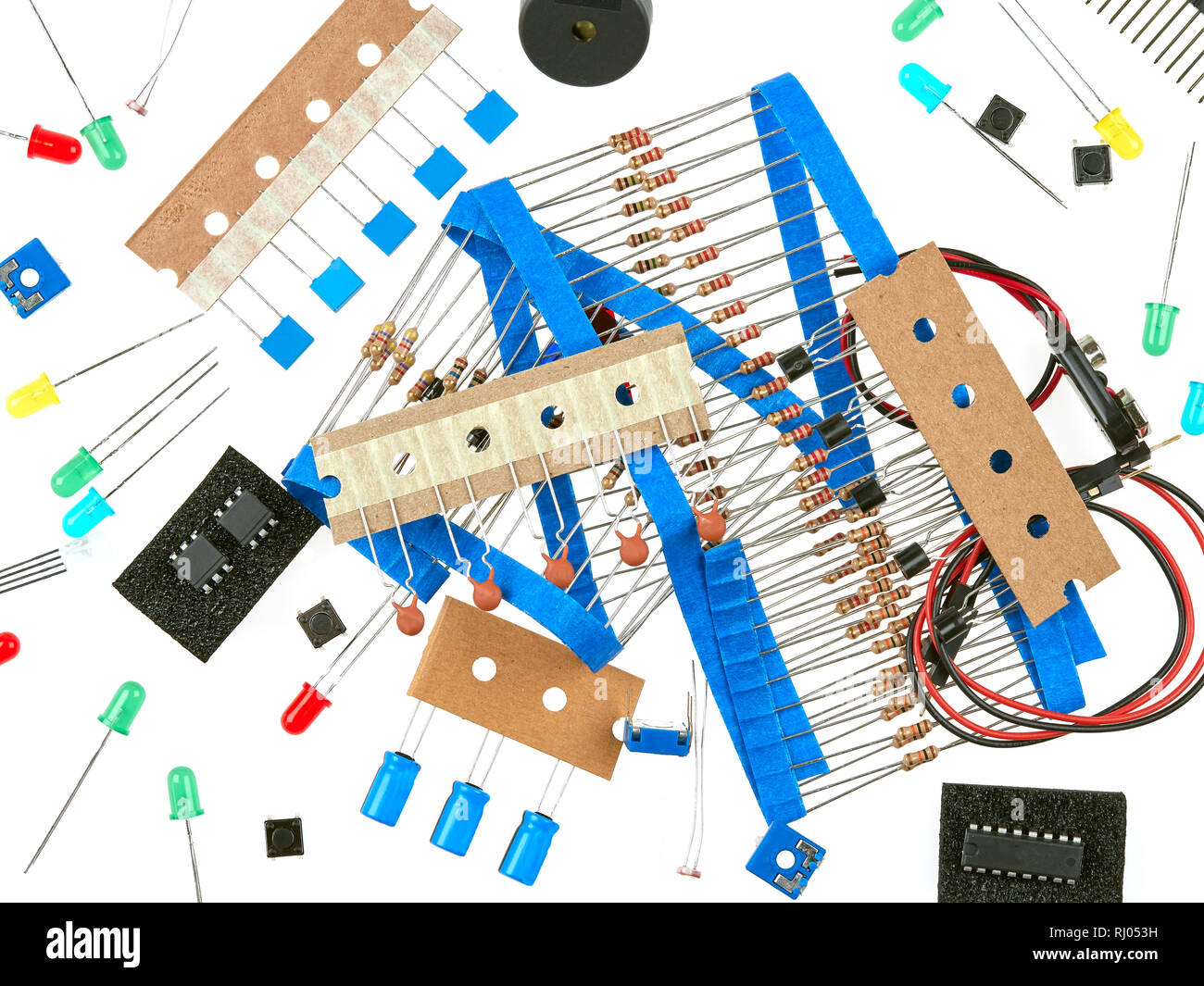 Una selezione di attiva e passiva componenti elettronici: pulsanti, LED, resistori, condensatori, cicalino, cavi di collegamento e transistori c integrato Foto Stock