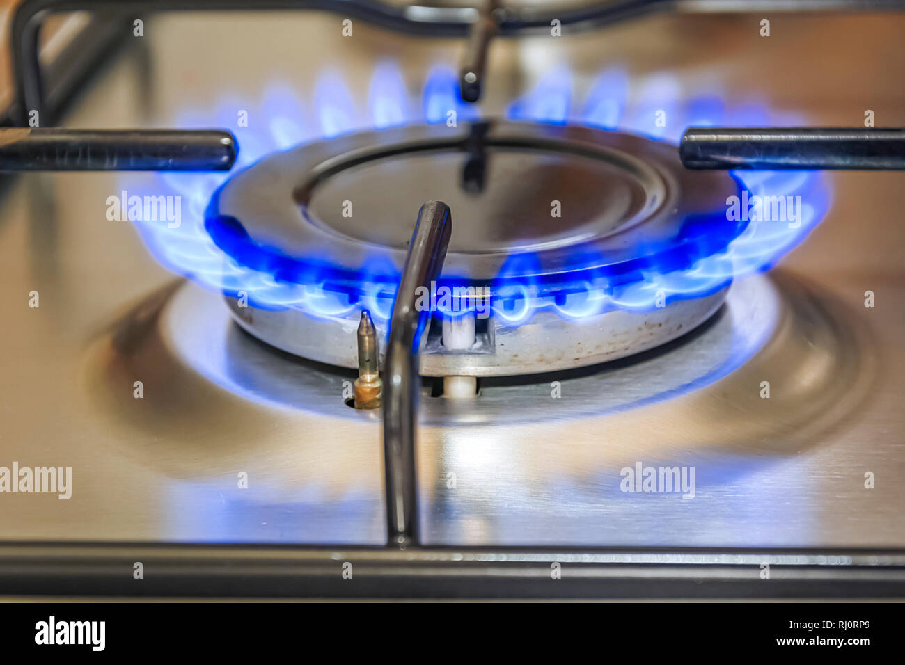 Vista ravvicinata di un fornello da cucina con fiamma blu. Cucina a gas e il concetto di energia Foto Stock