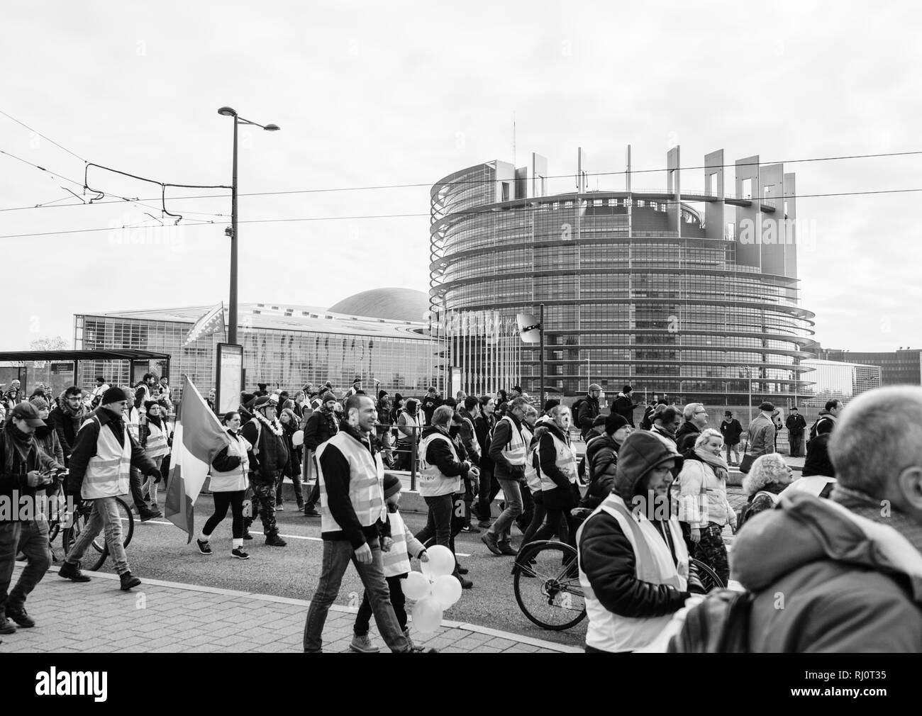 Strasburgo, Francia - Feb 02, 2018: Gilets Jaunes Giubbotto giallo manifestanti francese con bandiera nazionale marciando su 12 Sabato di manifestazioni antigovernative anteriore del Parlamento europeo in bianco e nero Foto Stock
