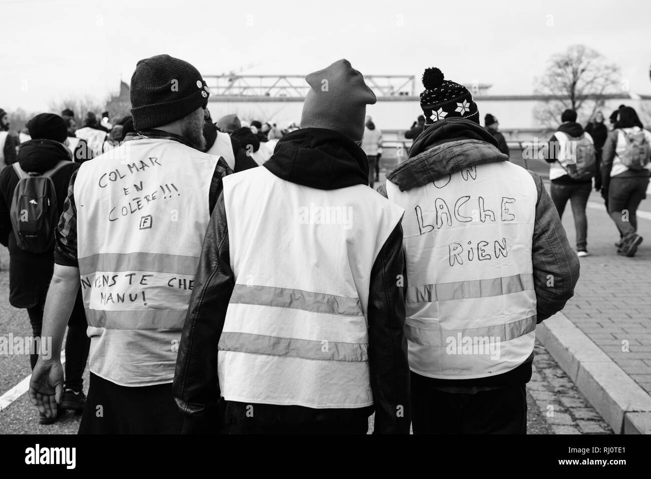 Strasburgo, Francia - Feb 02, 2018: Amici dimostrando durante la protesta di Gilets Jaunes Giubbotto giallo contro Emmanuel Macron e governo effettivo più iscrizioni su canottiere - bianco e nero Foto Stock