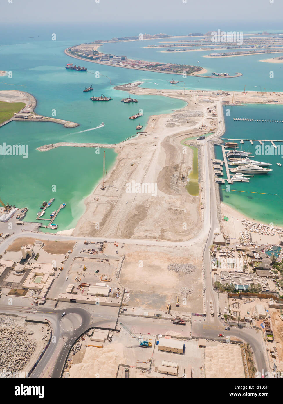 Costruzione di un'isola artificiale Palm Jumeirah con attrezzature da costruzione a Dubai. Foto Stock