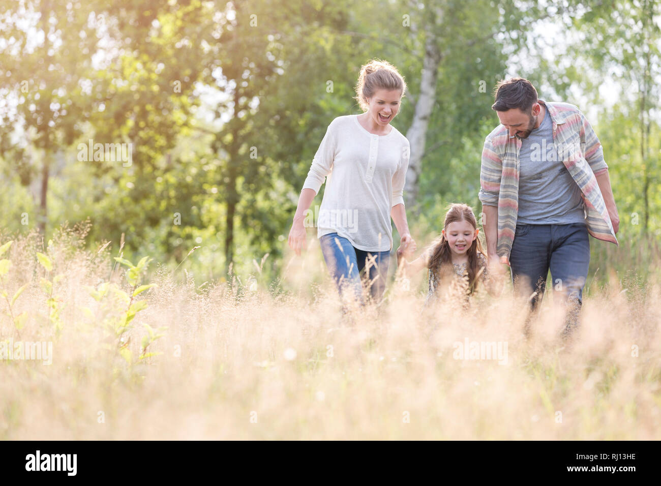 La famiglia felice camminando sul campo in terreni agricoli Foto Stock