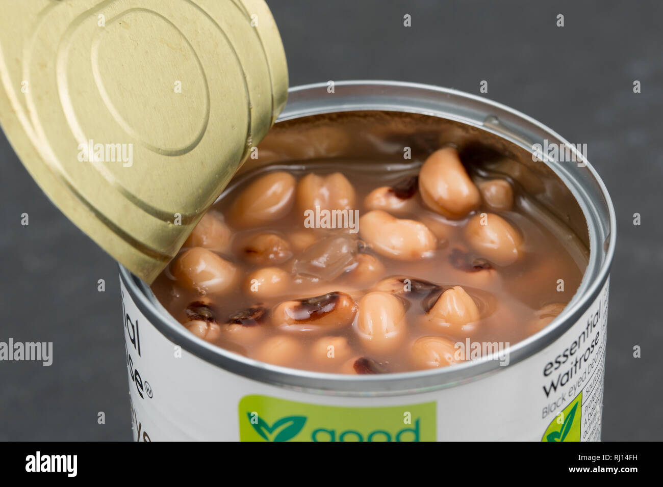 Un aperto può dei black eyed i fagioli in acqua hanno comprato da un supermarket Waitrose. Inghilterra REGNO UNITO GB. Fotografato su un oscuro, ardesia sfondo. Foto Stock