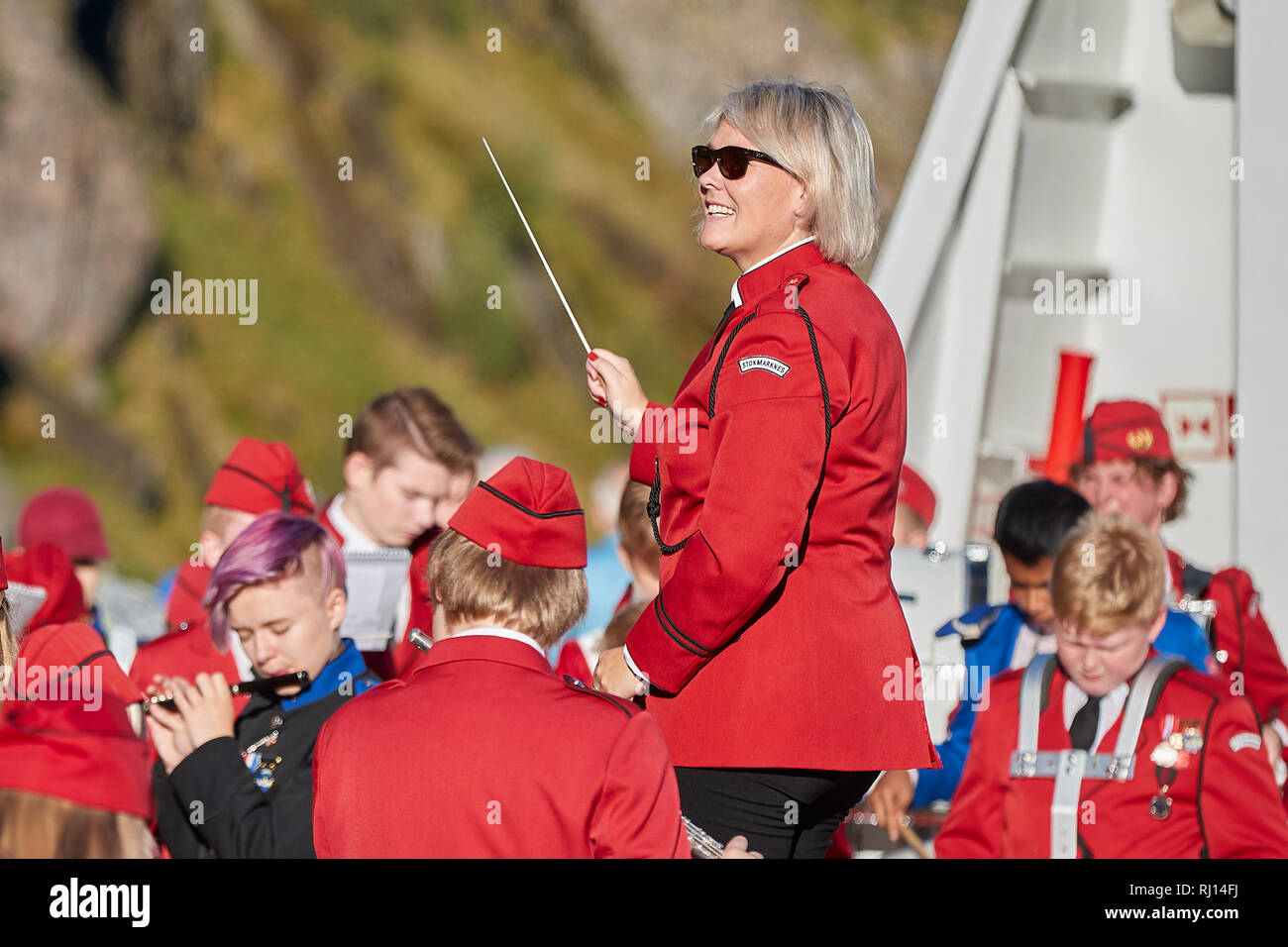 Harstad Stokmarknes e bande di scuola giocando sul ponte della MS Trollfjord come Naviga attraverso le strette Trollfjord, Isole Lofoten in Norvegia. Foto Stock