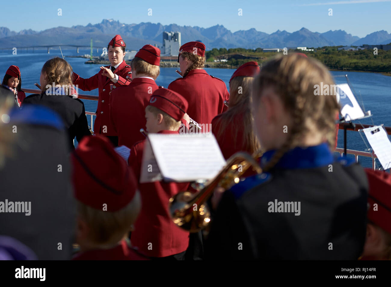 Harstad Scuola Band (Kanebogen Skolekorps) giocando sul ponte della MS Trollfjord, come esso si discosta Risøyhamn, Andøya, Norvegia. Foto Stock