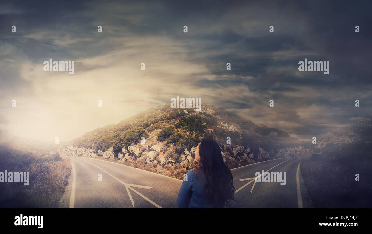 Vista posteriore della donna di fronte il bivio forcella junction road diviso in due modi diversi. La corretta scelta del percorso tra destra e sinistra, guasto o suc Foto Stock