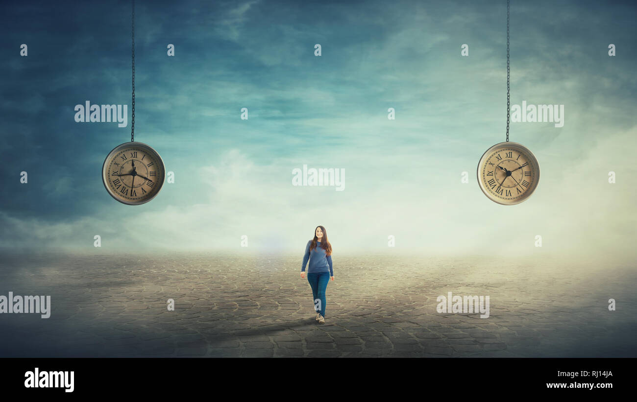 Scena surreale giovane donna a camminare su una pavimentazione stradale e due orologi sospeso sulla sua schiena appesi al cielo che mostra diverse ore. Il tempo di viaggio con Foto Stock