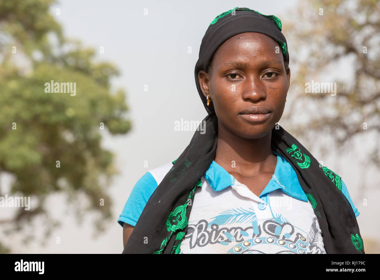 La-toden village, Provincia Yako, Burkina Faso. Abzeta Sourgou, 24, madre di 2, innaffiando le sue cipolle nel suo giardino del mercato. Essa utilizza una bicicletta per il trasporto di acqua da un pozzo che ha ancora acqua per la sua trama. Foto Stock