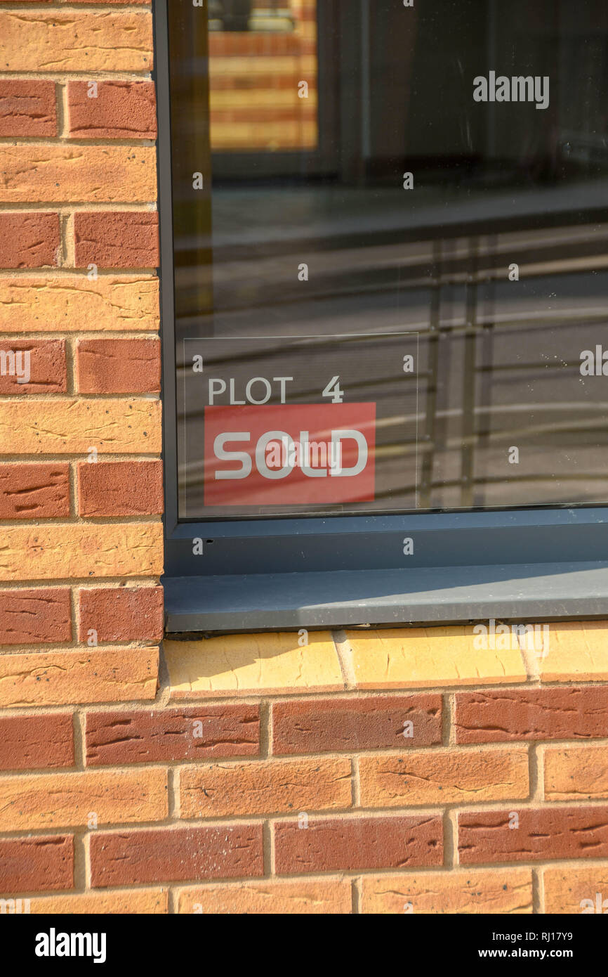 Un 'sold' avviso nella finestra di una nuova casa a Swansea, Galles Foto Stock