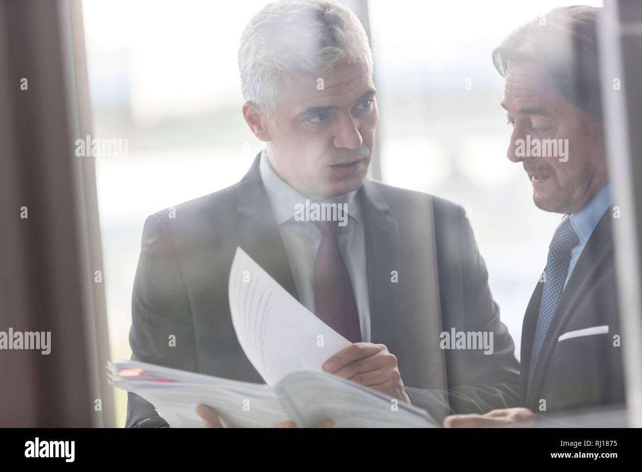 Imprenditori maturi discutendo su documento nel nuovo ufficio Foto Stock