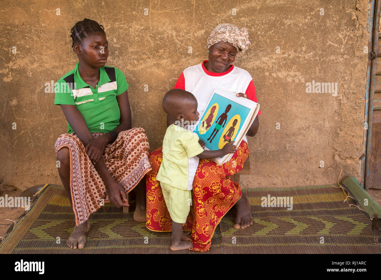 Il villaggio di Samba, Provincia Yako, Burkina Faso: Abzetta Sondo, 19, ed il suo bambino soffre di malnutrizione acuta, ottenere istruzioni di Helene Pagoundba, nutrizione istruzione membro del comitato. Foto Stock