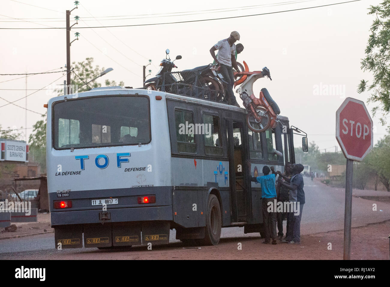 Yako town, Burkina Faso: caricare la moto su un tetto di bus per un lungo viaggio. Foto Stock