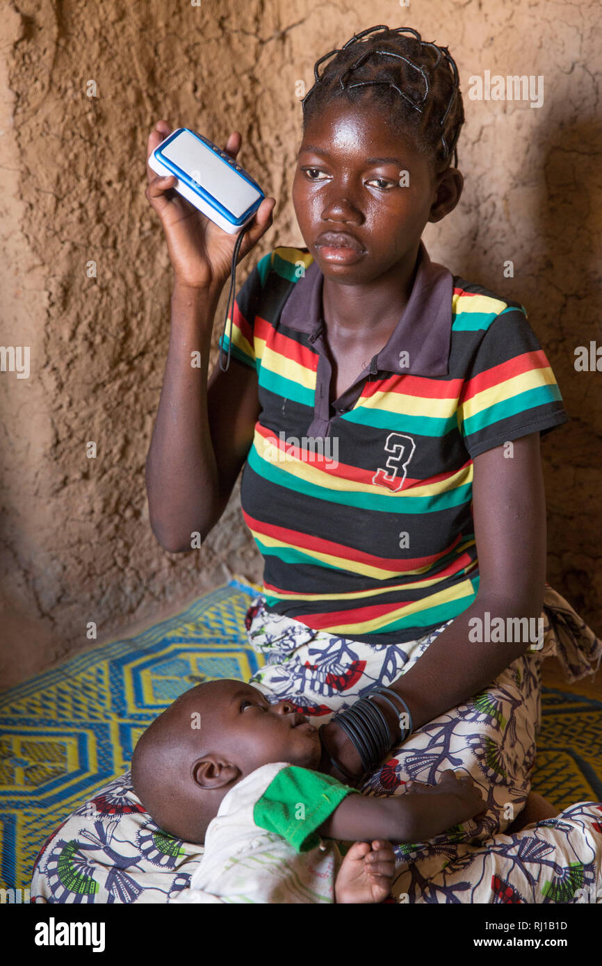 Il villaggio di Samba, Provincia Yako, Burkina Faso: Ascolto di un educational programma radio su nutrizione e sicurezza alimentare essendo trasmesso da Radio Natigmbzanga. Foto Stock