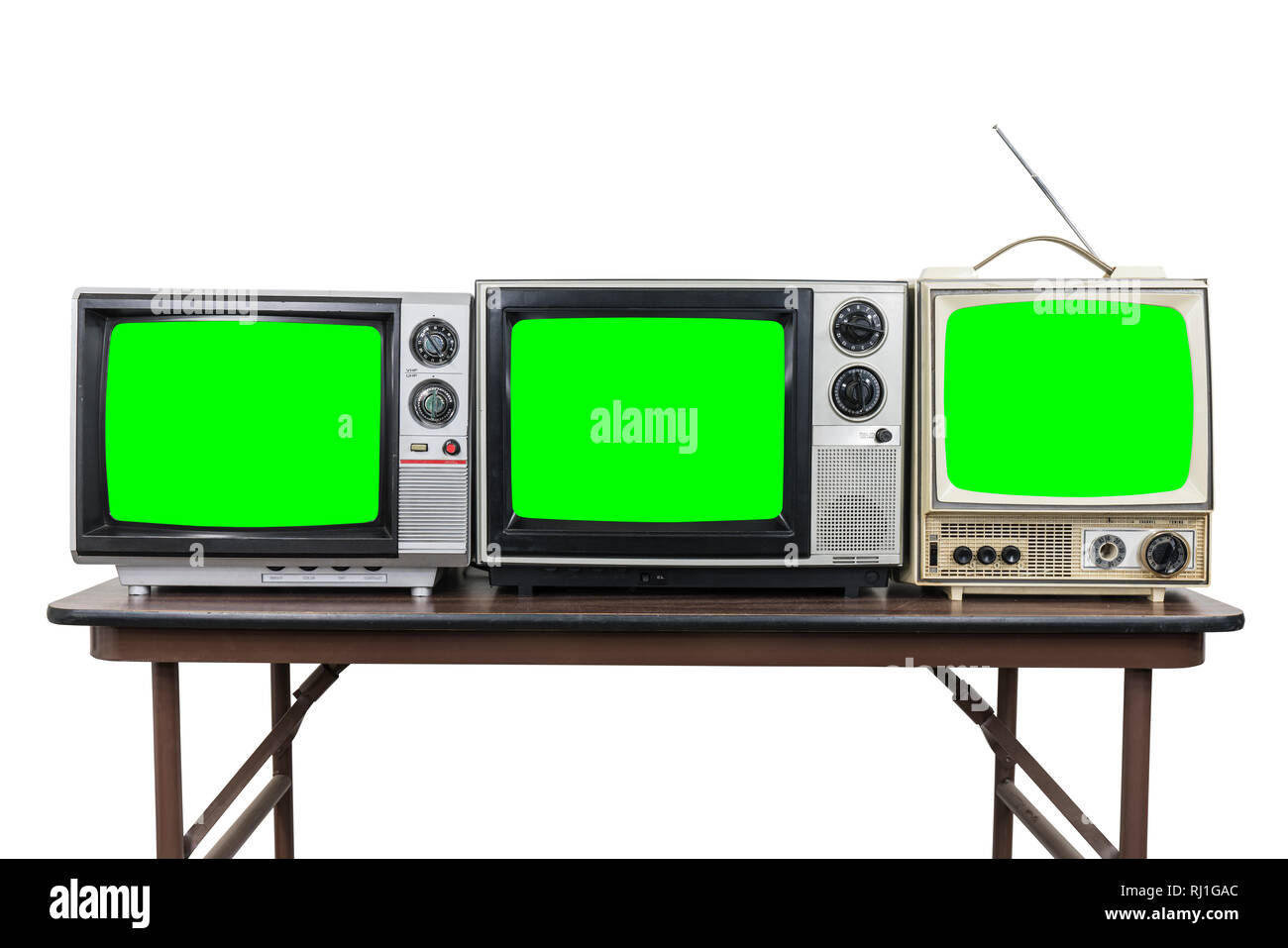 Tre televisori vintage sulla tavola di legno isolato su bianco con chroma key green schermate. Foto Stock