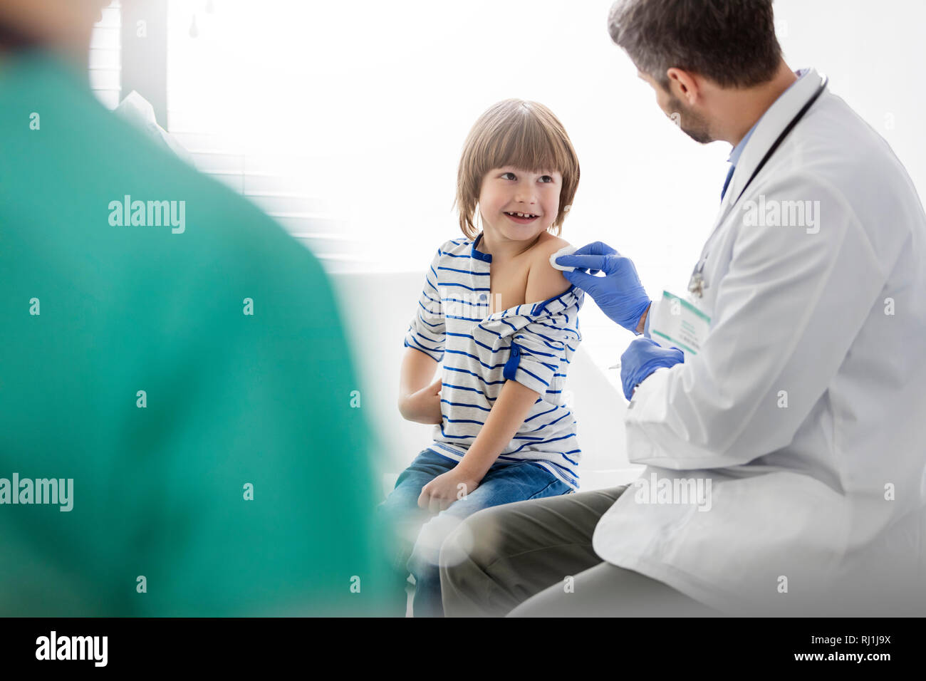 Metà adulto medico la vaccinazione del ragazzo in ospedale Foto Stock