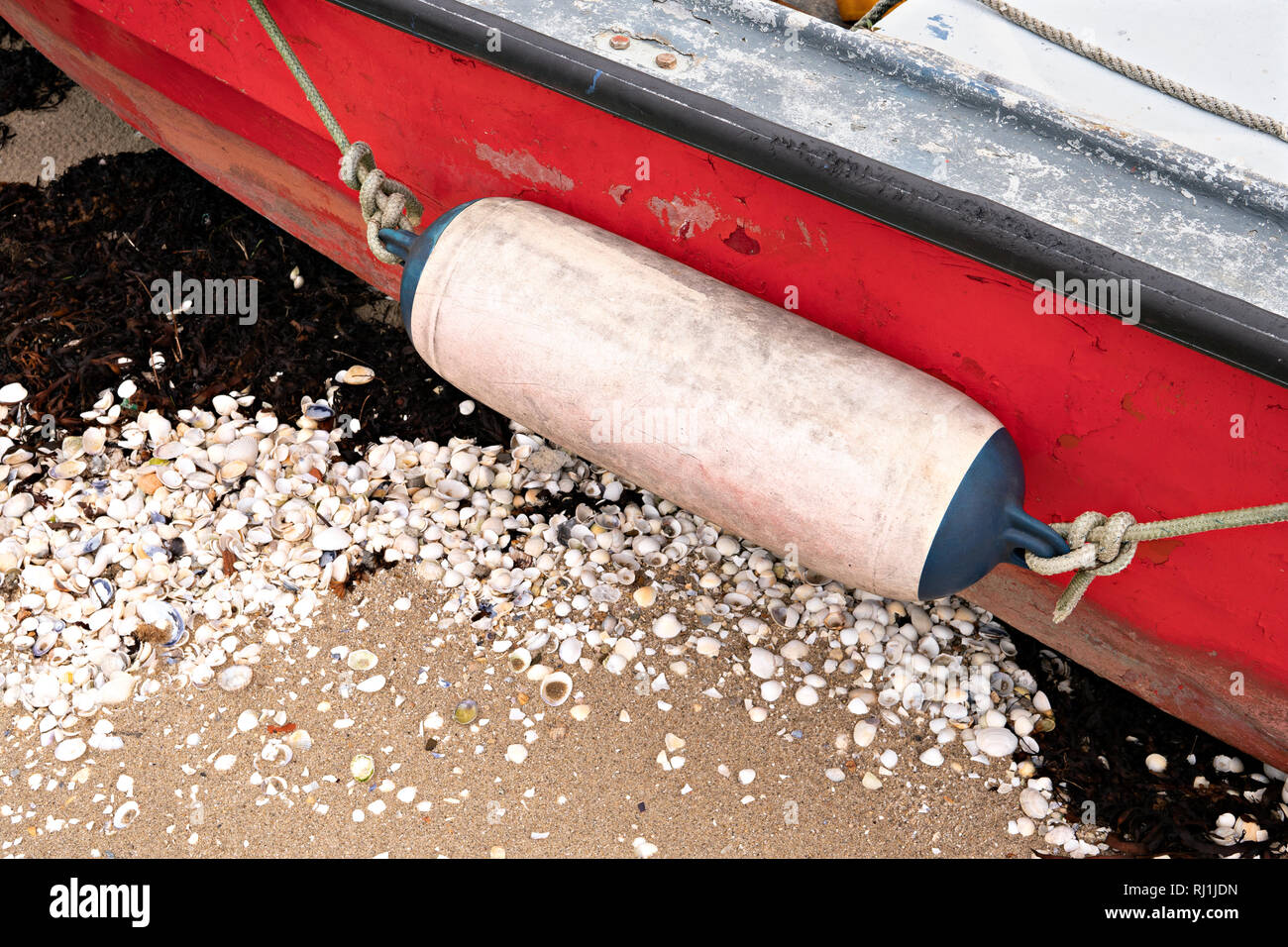 Di età compresa tra il parafango su una barca da pesca bloccati sulla spiaggia. Close up Foto Stock