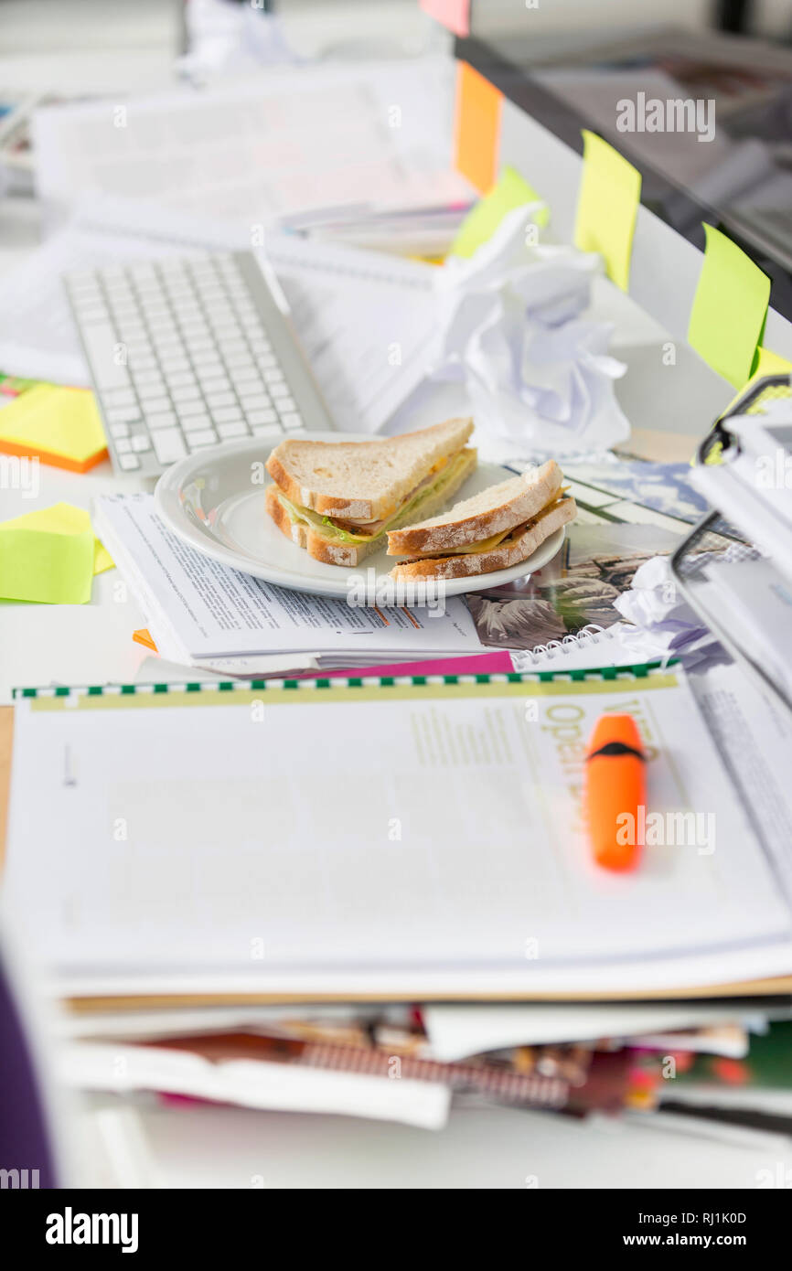 Vista dettagliata del sandwich e documenti sulla scrivania in ufficio Foto Stock
