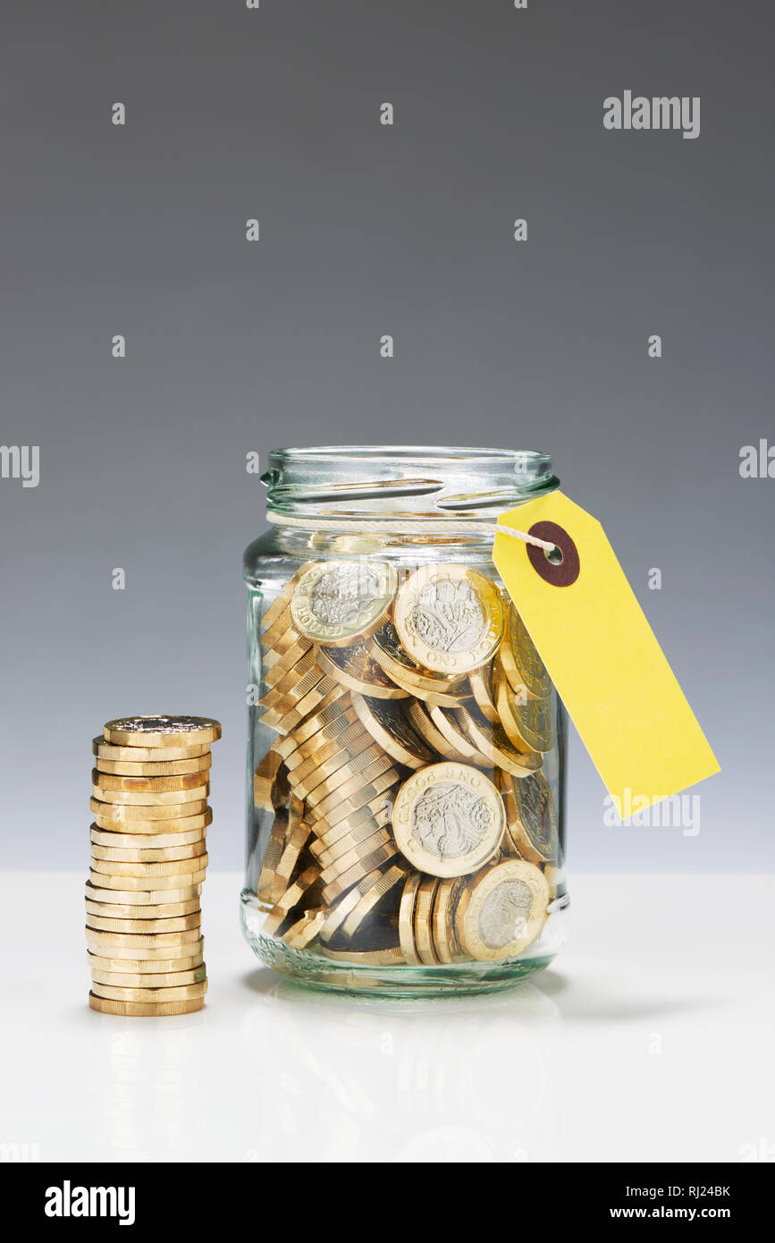 Risparmio di vetro vaso con una libbra di monete Foto Stock