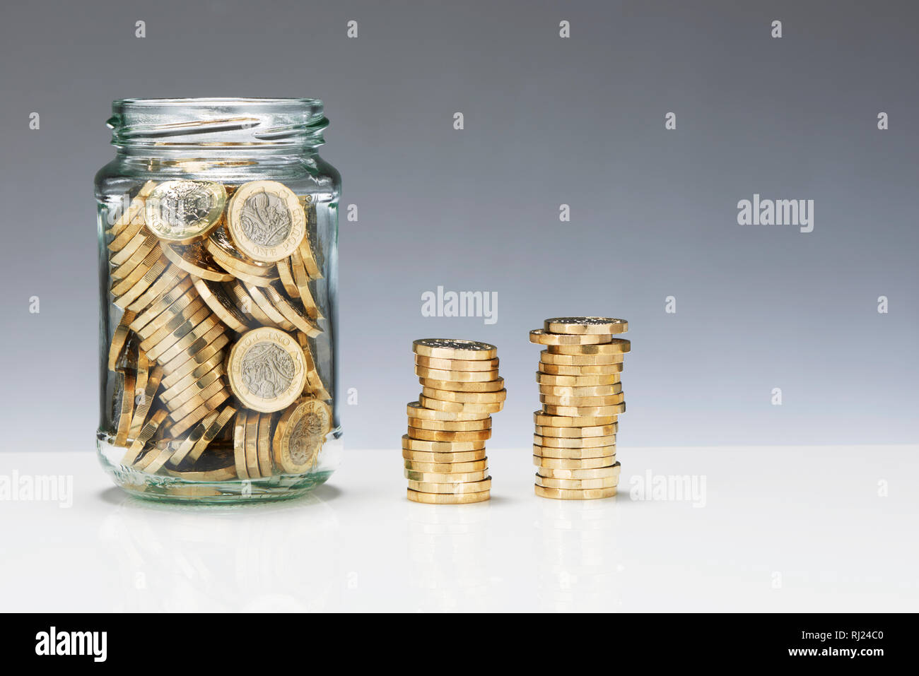 Risparmio di vetro vaso con una libbra di monete Foto Stock