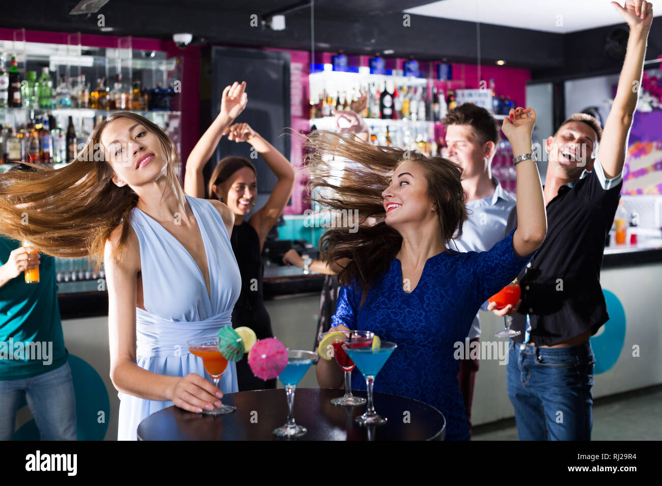 Due donne stanno bevendo un cocktail sulla corporate partito. Foto Stock