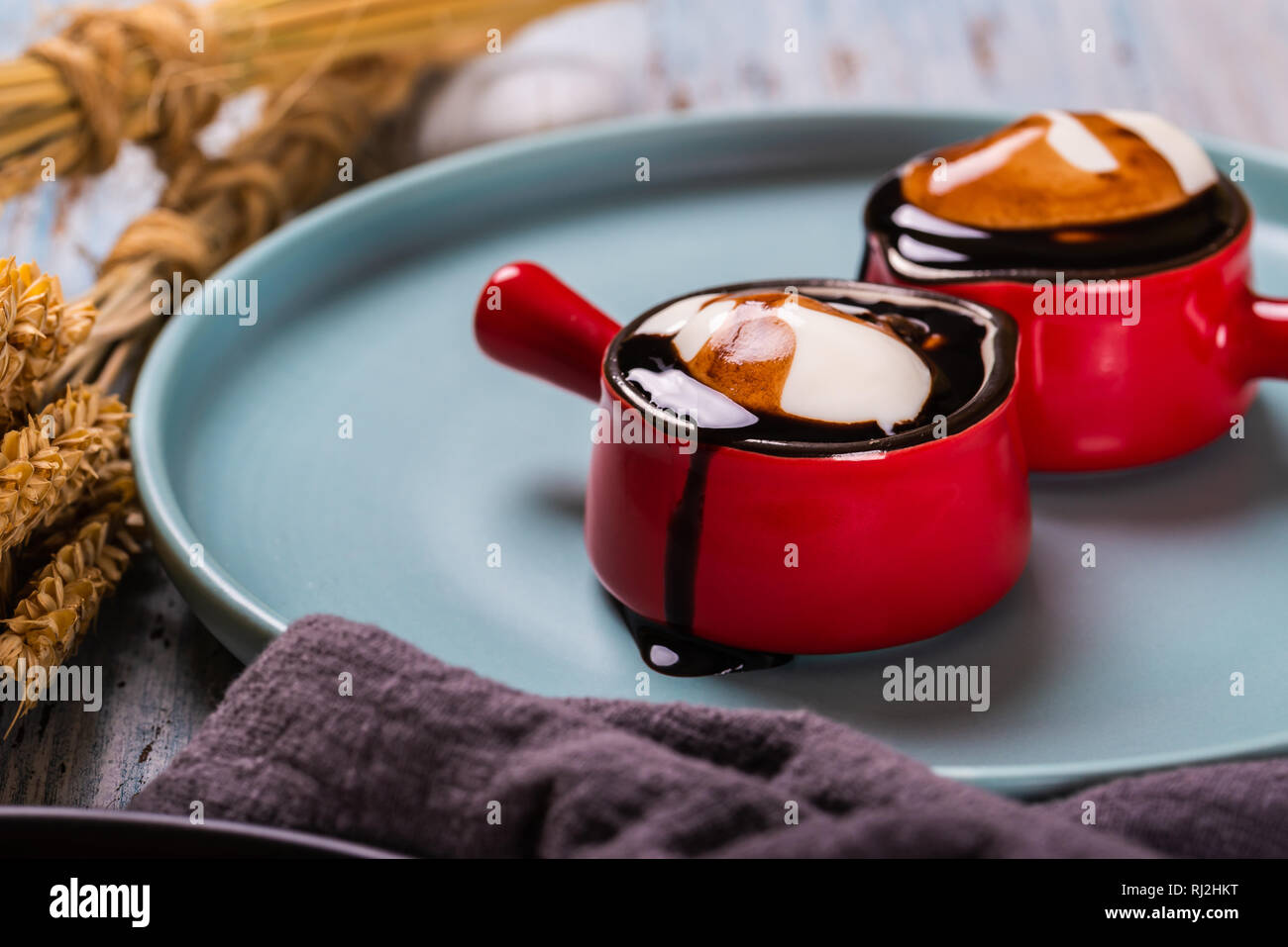 Bianco panna montata in due belle rosse piccole tazze con manico Foto Stock