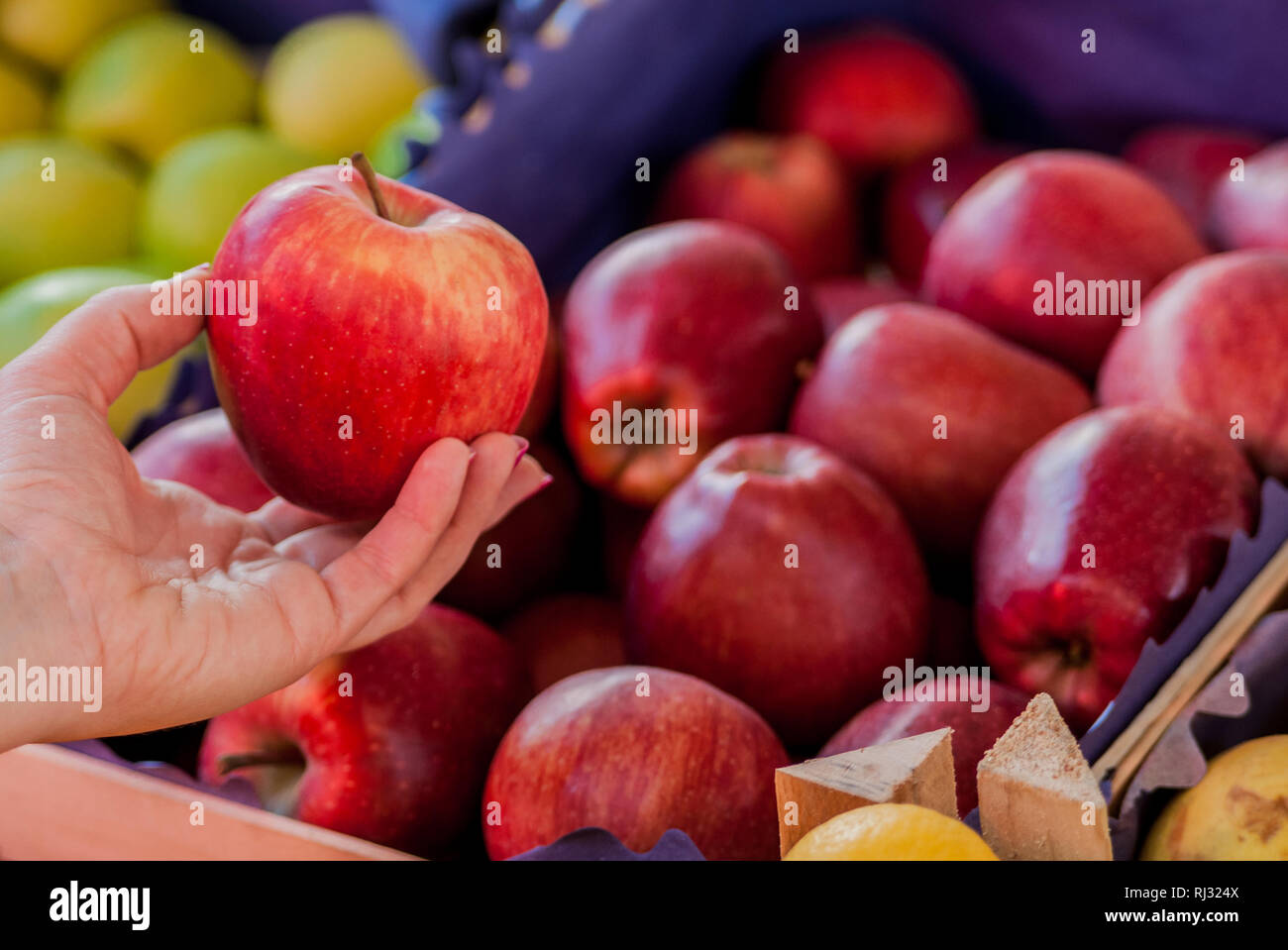 Solo i migliori frutti e verdure. Bella giovane donna azienda apple. Donna acquisto di un rosso fresco Apple in un mercato verde.. Donna organico acquisto appl Foto Stock